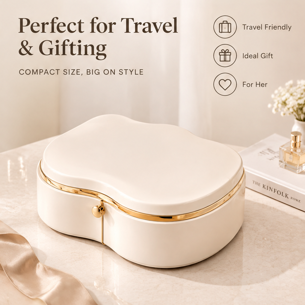 Perfect for travel and gifting — compact size, big on style. Travel friendly, ideal gift, for her. Closed cream cloud-shaped jewelry box with gold trim on marble surface next to Kinfolk book